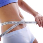 Measuring tape around slim beautiful waist.